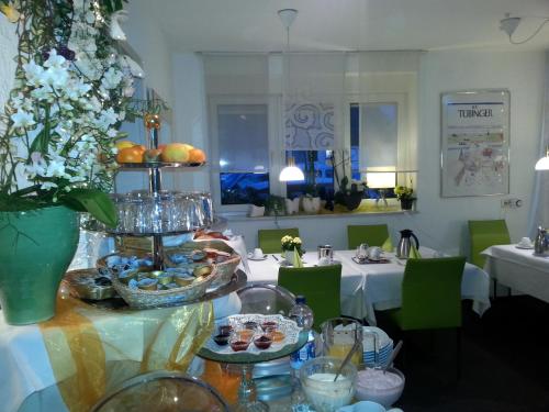a dining room with a table with food and flowers at Hotel Garni Sand in Tübingen