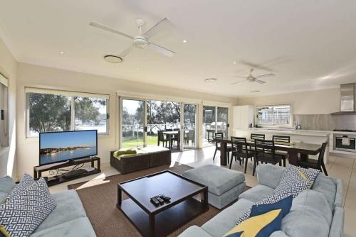 a living room with a couch and a dining room at Wangi Lakehouse in Wangi Wangi