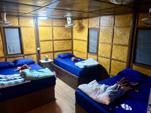 a room with three beds with people sleeping on them at New Hut Bungalow in Lamai