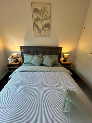 a bedroom with a large white bed with two lamps at NatureWalkBrookfield in Melton South