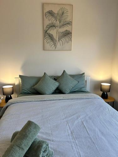 a bedroom with a bed with a palm tree painting on the wall at NatureWalkBrookfield in Melton South