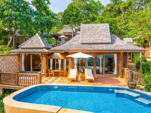 a house with a swimming pool in front of a house at Santhiya Koh Phangan Resort & Spa - Up to THB 2,000 Resort Credit per Night in Thong Nai Pan Noi