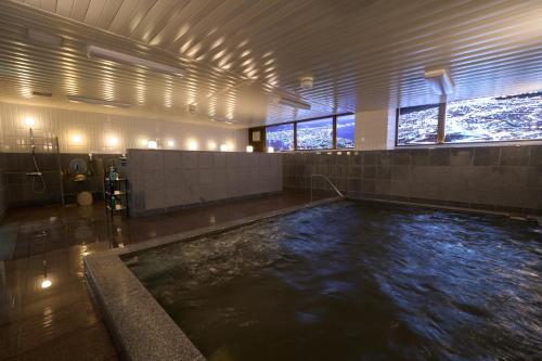 a pool of water in a building with a swimming pool at Hotel Hokke Club Hakodate in Hakodate