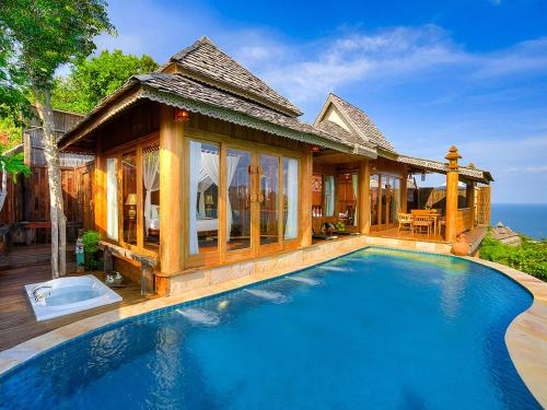 a villa with a swimming pool in front of a house at Santhiya Koh Phangan Resort & Spa - Up to THB 2,000 Resort Credit per Night in Thong Nai Pan Noi