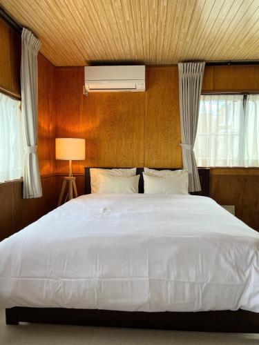 a bedroom with a large white bed and windows at Shell Beach Hamanako - Vacation STAY 14730 in Hamamatsu