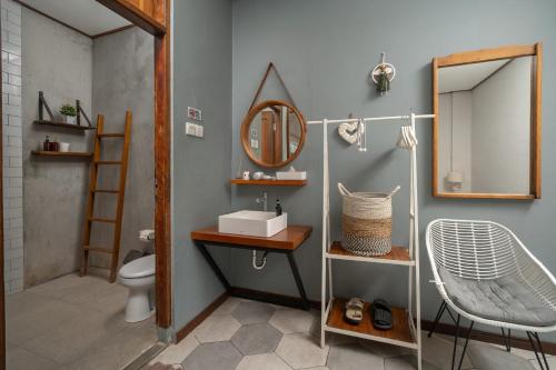 a bathroom with a sink and a mirror and a toilet at Interconnection Hostel in Kuta