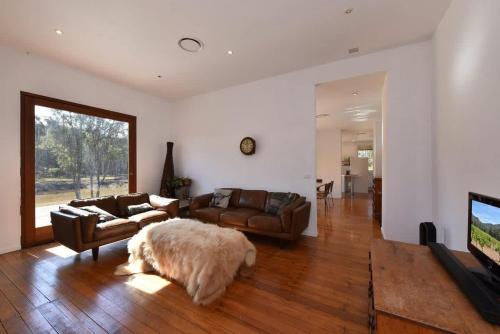 a living room with a couch and a tv at The Parsons Retreat in Rothbury