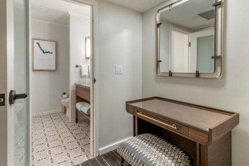 a bathroom with a vanity and a mirror at Omni La Mansion del Rio in San Antonio