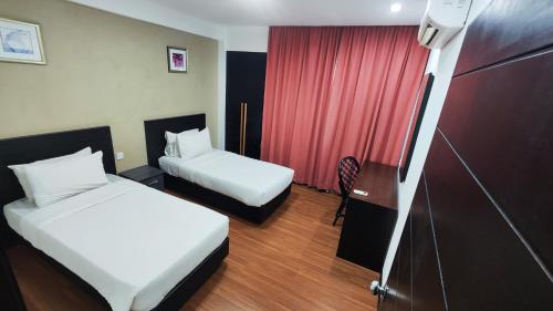 a hotel room with two beds and a red curtain at Likas Square - KK Spacious Homestay in Kota Kinabalu