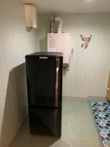 a black refrigerator in the corner of a kitchen at Formosa Hakodate - Vacation STAY 17455 in Hokuto