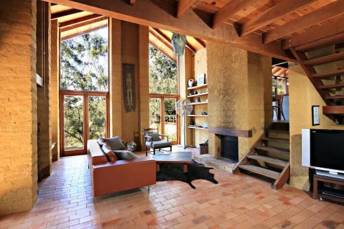 a living room with a couch and a fireplace at Corymbia Cottage Brokes Secluded Escape for max 4 in Broke