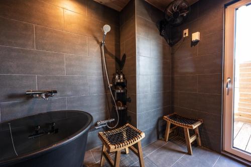 a bathroom with a tub and two stools at Obaranchi - Vacation STAY 18154 in Kawasaki