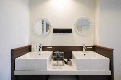 a bathroom with two sinks and two mirrors at R Hotel - Vacation STAY 19198 in Chiba