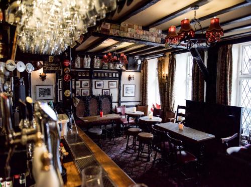 a bar with tables and chairs and chandeliers at The Black Boy Inn in Caernarfon