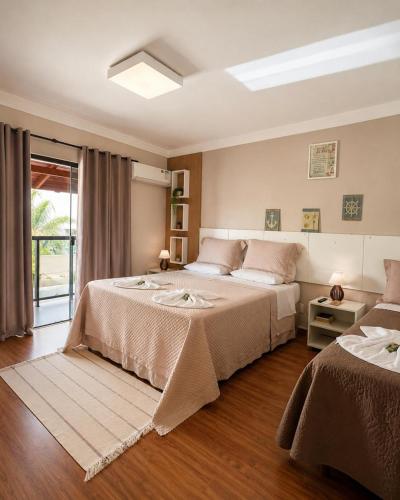 a bedroom with two beds and a window at Pousada Casa Da Praia in Florianópolis