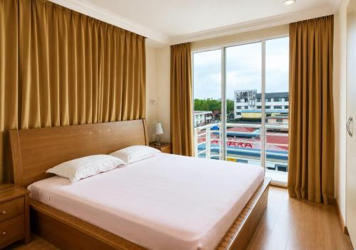 a bedroom with a large bed and a large window at Kudat Ria Hotel Plt in Kudat