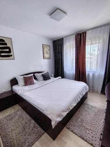 a bedroom with a large bed and a window at Adrian Home City in Ploieşti