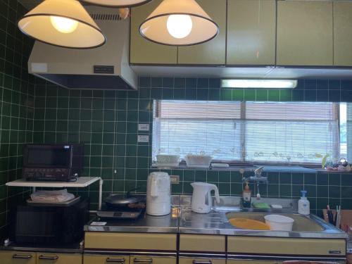 a kitchen with green tiled walls and a sink at Kohaku - Vacation STAY 20481 in Nagahama