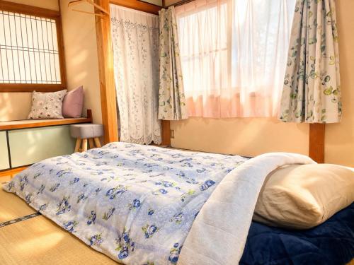 a bedroom with a bed and a window with curtains at Kohaku - Vacation STAY 20481 in Nagahama