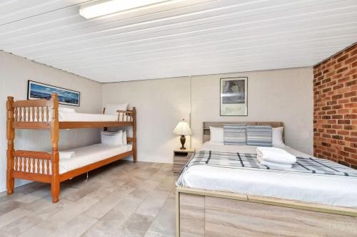 a bedroom with a bunk bed and a brick wall at Noble Willow Studio Lovedale. A Cosy Unique Wine Country Refuge in Lovedale