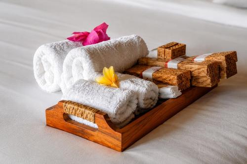 a wooden tray with towels and a bunch ofww at Kayangan Villa Ubud in Ubud