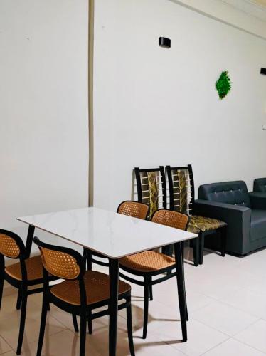 a table and chairs in a room with a couch at Chendering Beach Stay in Kuala Terengganu