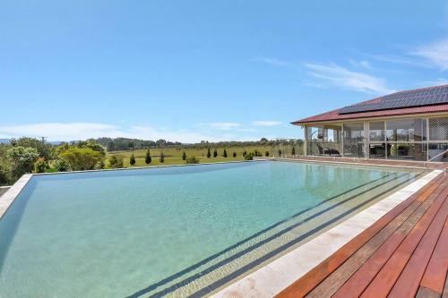 an empty swimming pool on a wooden deck next to a house at Noble Willow Estate in Lovedale