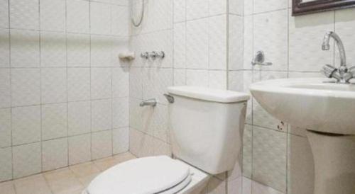 a white bathroom with a toilet and a sink at Boracay Breeze Resort in Boracay