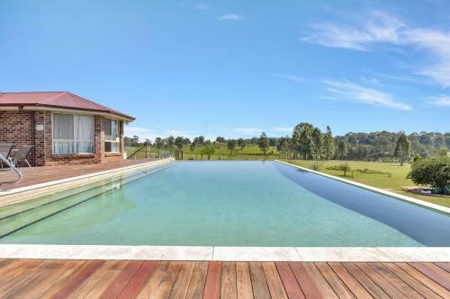 an empty swimming pool in a house with a wooden deck at Noble Willow Homestead in Lovedale