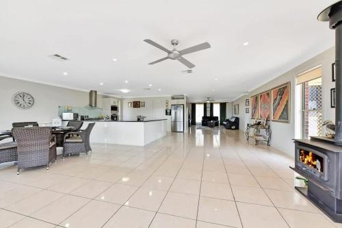 a living room with a ceiling fan and a fireplace at Noble Willow Homestead in Lovedale