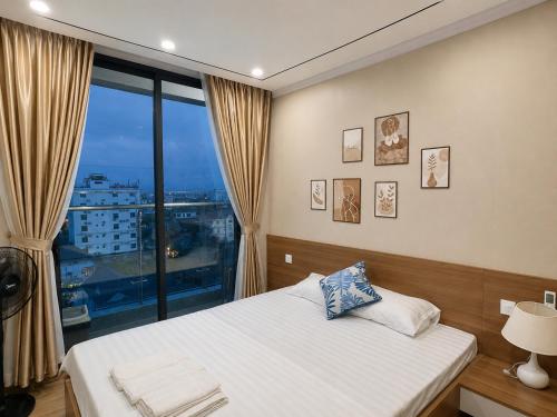 a bedroom with a bed and a large window at Beer's Homes Căn hộ chung cư Pearl Residence in Cửa Lô