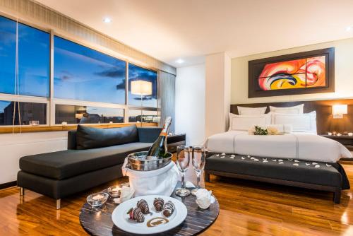 a hotel room with a bed and a couch at One Sixteen Hotel in Bogotá