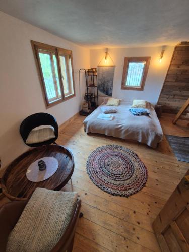 a bedroom with a bed and a wooden floor at Bat's Cave Hut Transylvania - Rustic Retreat in Sub Piatra