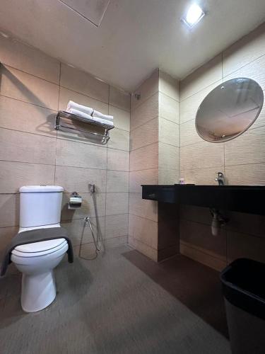 a bathroom with a toilet and a sink and a mirror at Likas Square - KK Apartment Suite in Kota Kinabalu
