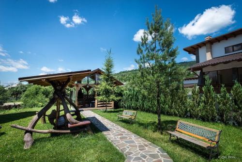 a park with a gazebo and two benches at Pensiunea Royal in Borşa