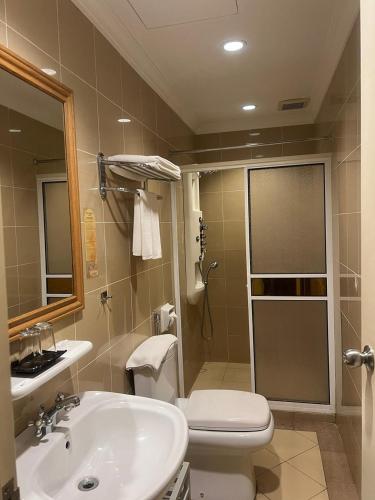 a bathroom with a shower and a toilet and a sink at Kudat Ria Hotel Plt in Kudat