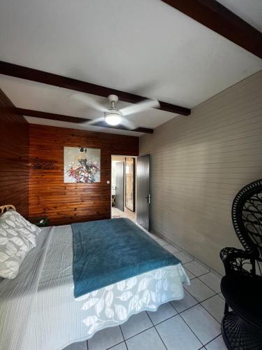 a bedroom with a large bed with a wooden wall at La Caze Vital in Saint-Joseph