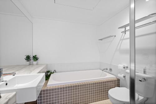 a bathroom with a tub and a toilet and a sink at Potters Hill Haven in San Remo