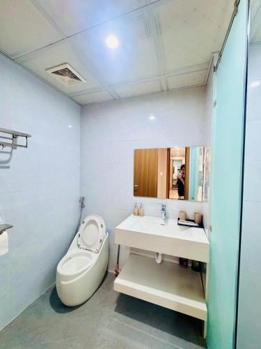a bathroom with a toilet and a sink and a mirror at Beer's Homes Căn hộ chung cư Pearl Residence in Cửa Lô