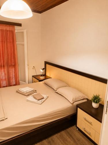 a bedroom with a bed with two towels on it at Mikel's Village House in Káto Garoúna