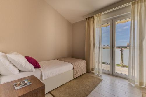 a bedroom with a bed and a large window at Villa Badi in Umag