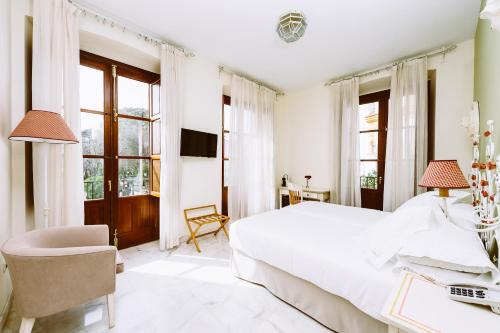 セビリアにあるBasic Hotel Doña Manuelaの白いベッドルーム(大型ベッド1台、デスク付)
