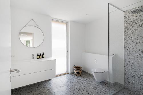 a white bathroom with a sink and a mirror at Holiday Home On Bornholm Close To Sea And Beach in Vester Sømarken