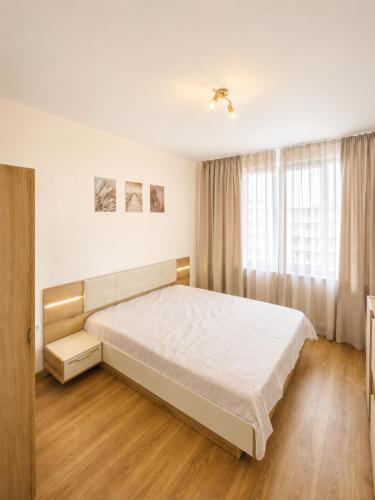 a bedroom with a large bed and a window at Pool View Apartment Varna in Varna City