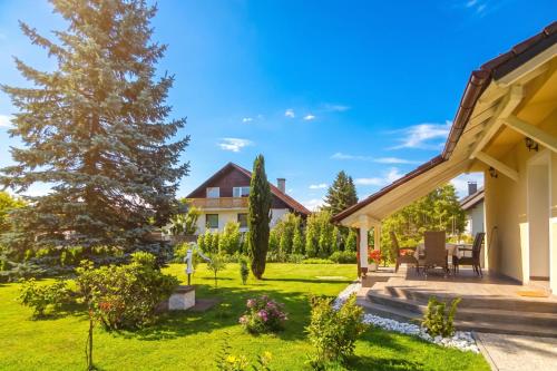 a garden with a house and a tree at Villa Cujez with Pool & Sauna - Happy Rentals in Rečica ob Savinji
