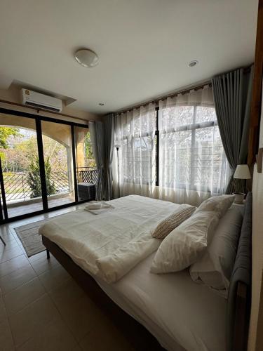 a bedroom with a large bed with a large window at Clock Tower Apartments Chroma Pulse in Pai