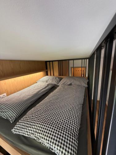 a bed with black and white sheets in a room at Apartmán Na Hvězdné Mýtince in Jeseník