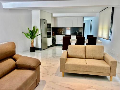 a living room with two couches and a kitchen at O Lar de LUCI in Nigrán