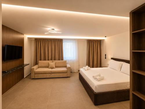 a hotel room with a bed and a couch at Bedo Boutique Hotel in Golem