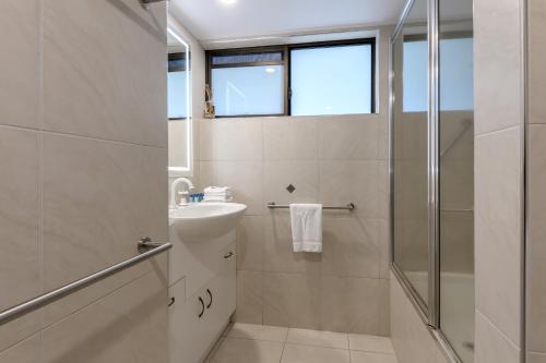 a bathroom with a sink and a shower at Seascape Holidays - Tropical Reef Apartments in Port Douglas